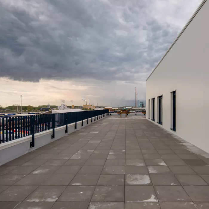 Terras bovenste verdieping kantoor SEA Invest DFDS. Links bevindt zich de balustrade van het terras. Rechts een deel van het gebouw.