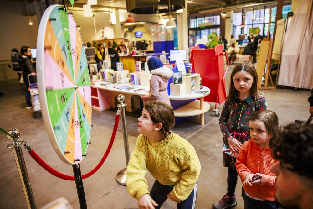Kinderen schuiven aan om aan een rad te draaien