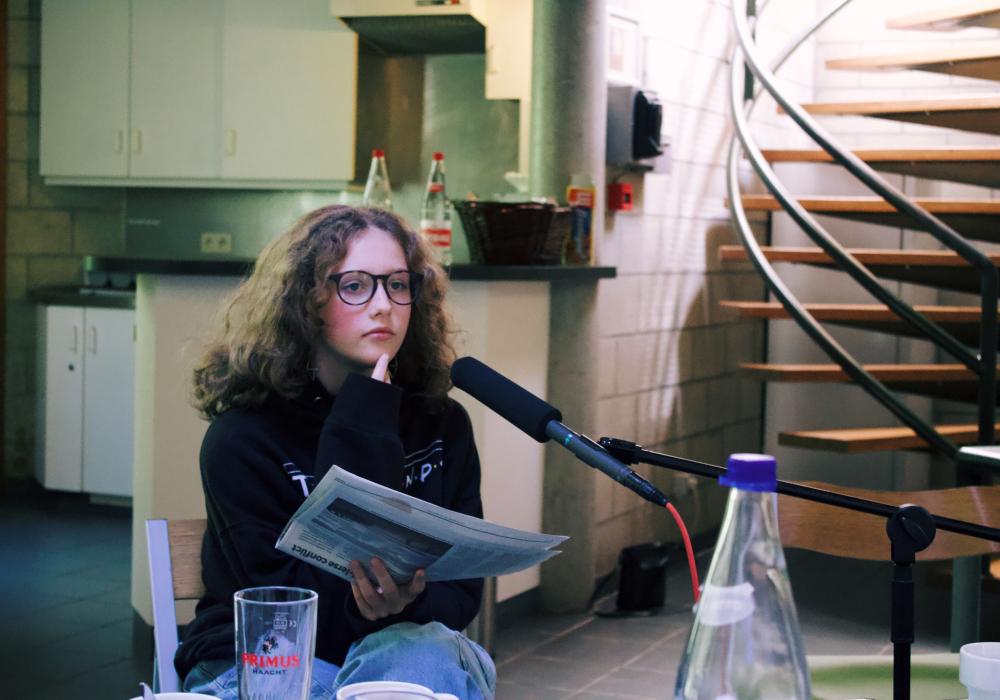 Een jongere kijkt bedachtzaam en neemt een podcast op