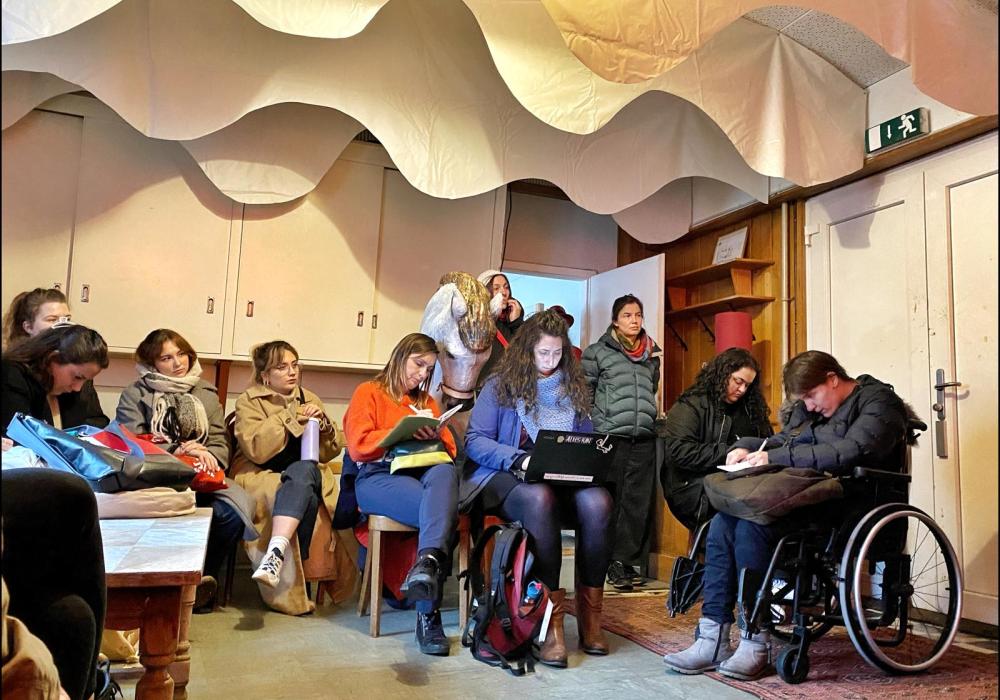 Jeugdwerkers in een workshop, verschillende mensen in beeld die aan het noteren zijn, waaronder een persoon in een rolstoel