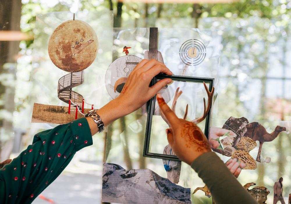 deelnemers werken aan de collage op het raam