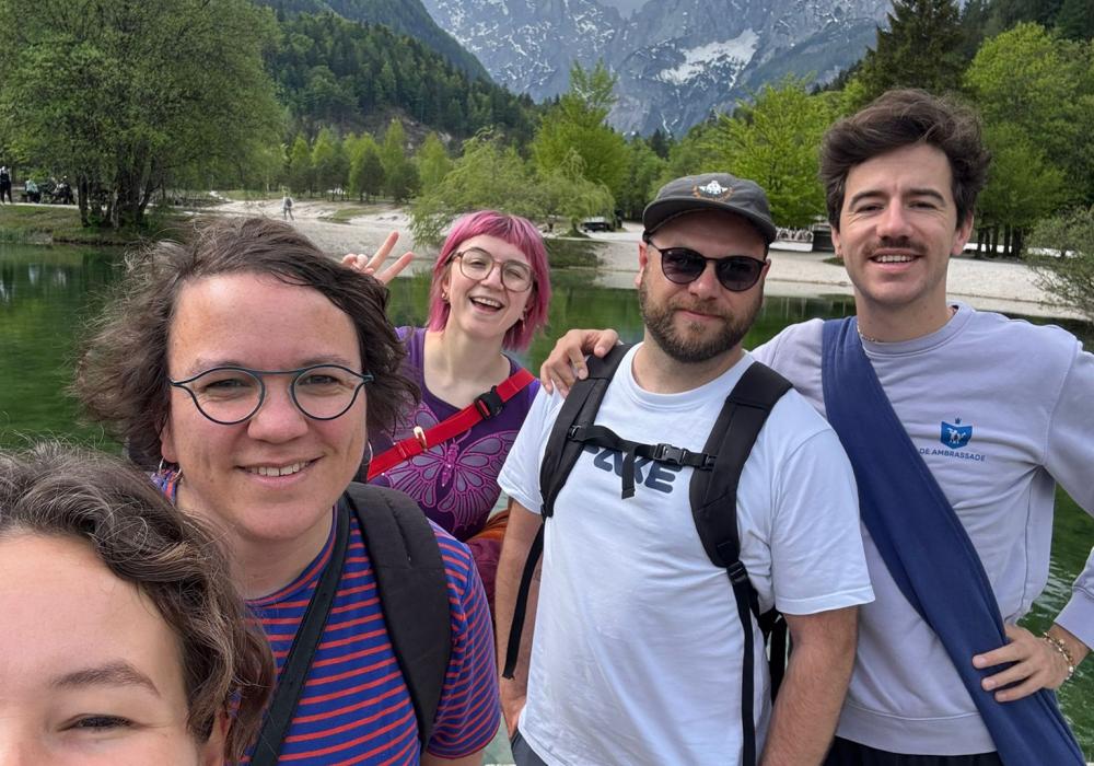 Selfie van 5 deelnemers met meer en bergen achter zich