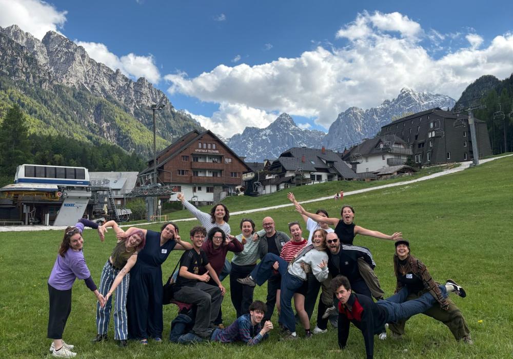 Groep poseert in gekke poses met bergen op de achtergrond