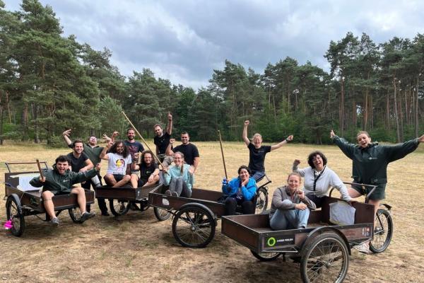 De internationale vrijwilligers namen tijdens het reünieweekend op De Hoge Rielen deel aan een knotsgekke bakfietsenrace, in goede banen geleid door enkele personeelsleden. - Beeld: Bart Van den Langenbergh