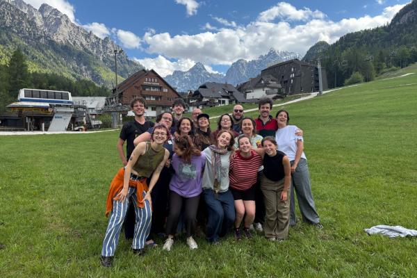 Groep poseert in vallei met bergen op de achtergrond