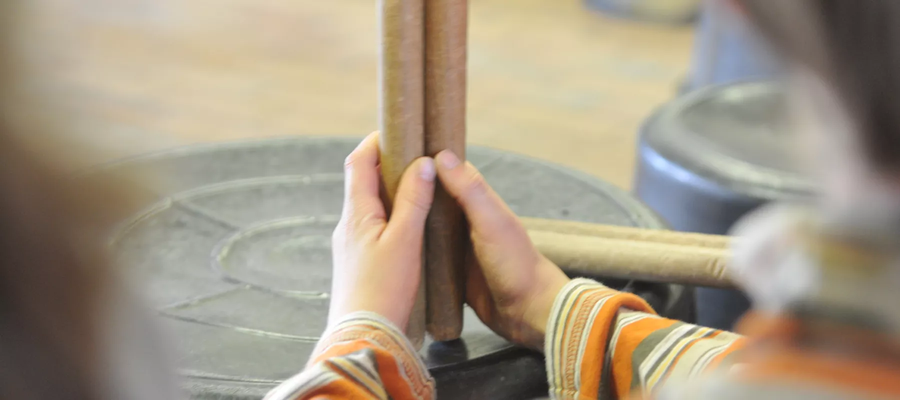 Kind met drumstokken en slaginstrument tijdens workshop