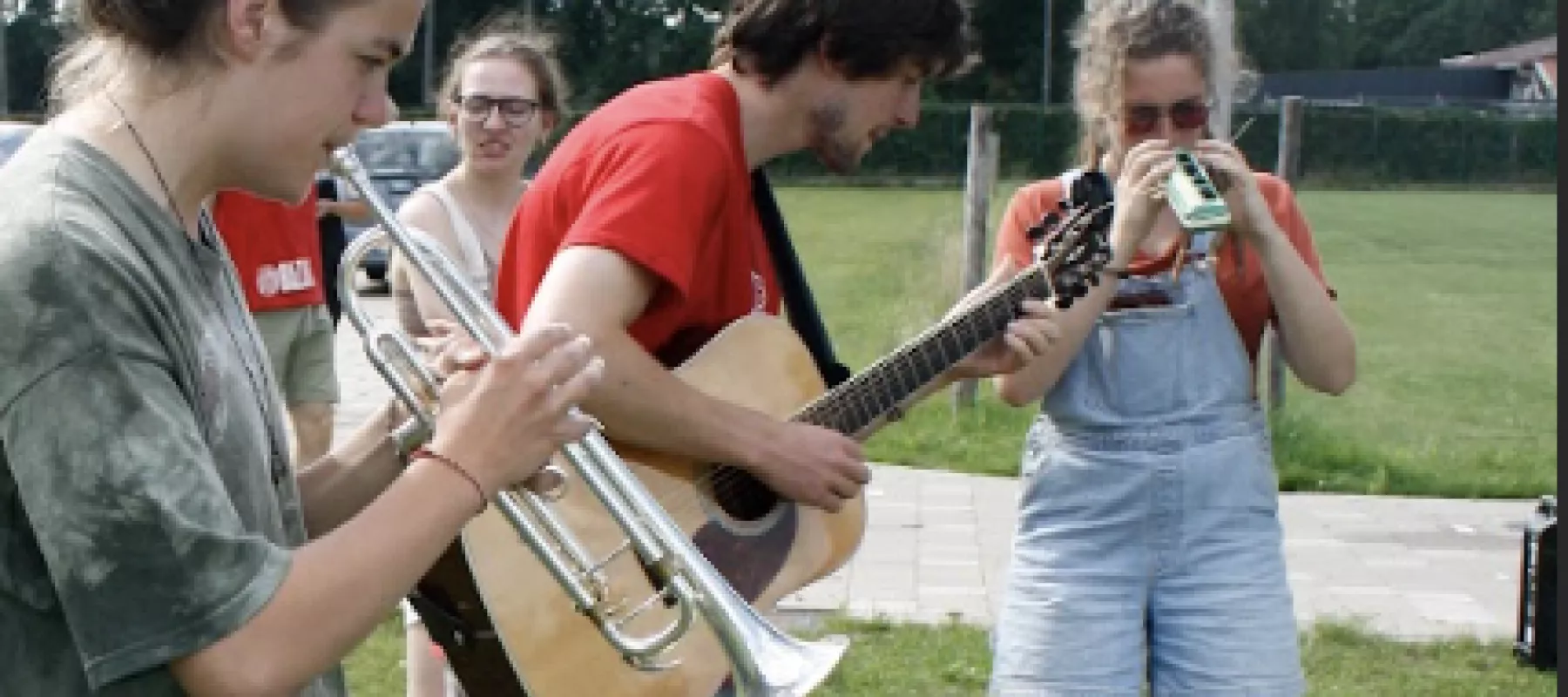 Tieners spelen samen muziek: trompet, gitaar en melodica Tieners spelen samen muziek: trompet, gitaar en melodica