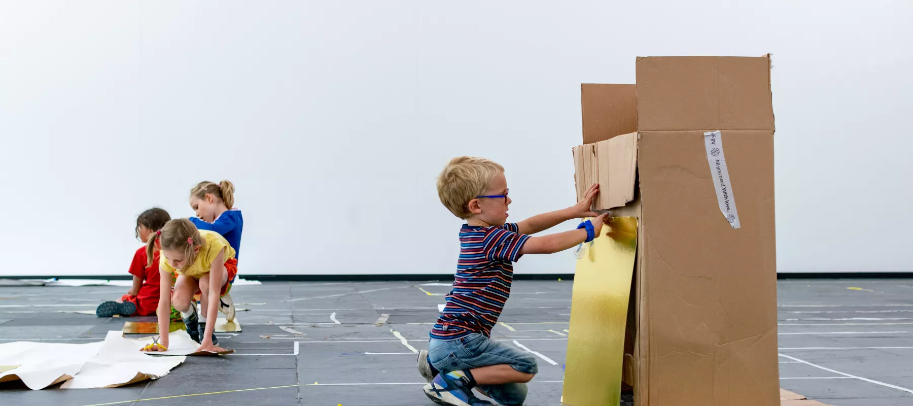 Kinderen knutselen met grote kartonnen dozen