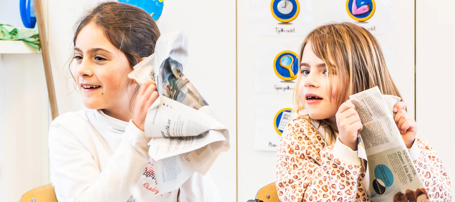 Foto door Lien Janssens Kinderen maken geluid met kranten en luisteren ernaar