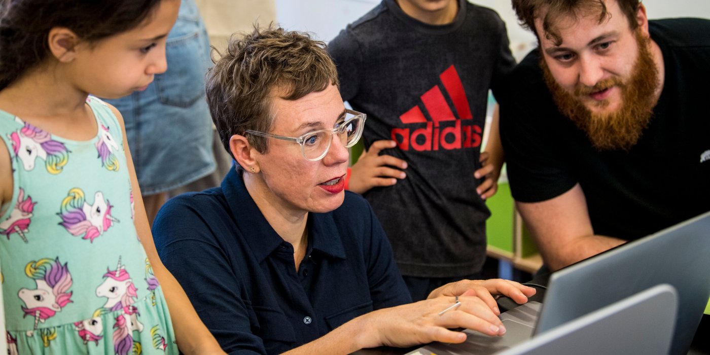 2 volwassenen en 2 kinderen zoeken iets op op een computer
