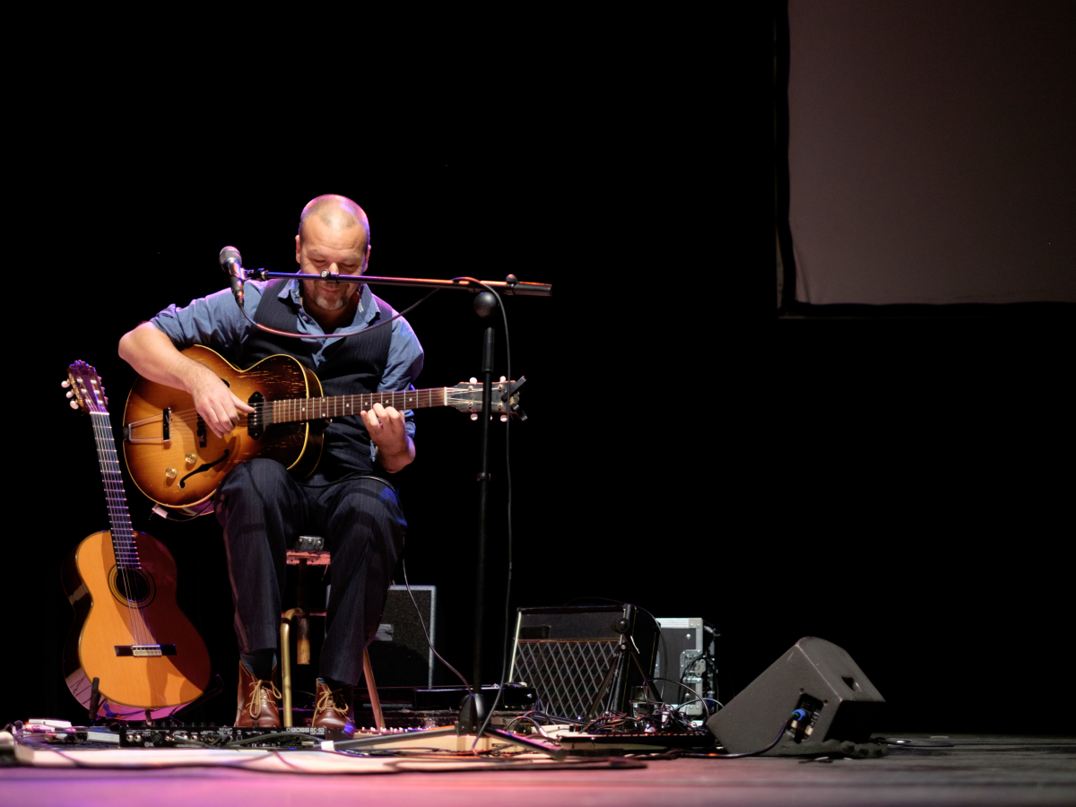 Een gitarist op het podium.