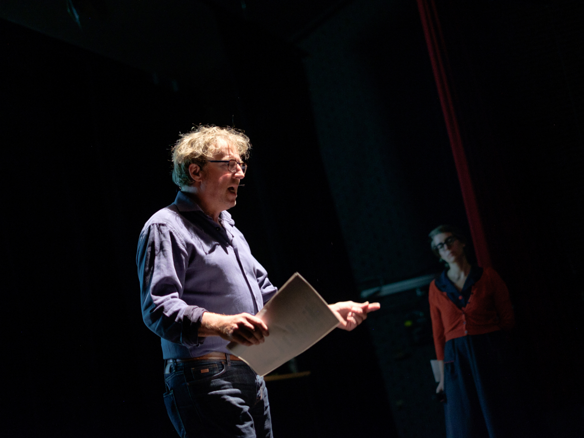 Een man die een lezing geeft op een podium.