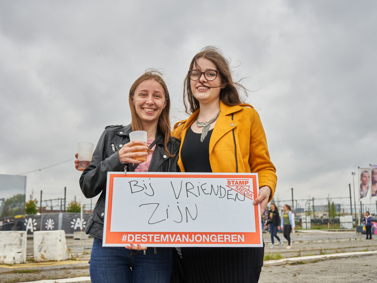 Jongeren met bordje vast met 'bij vrienden zijn' op