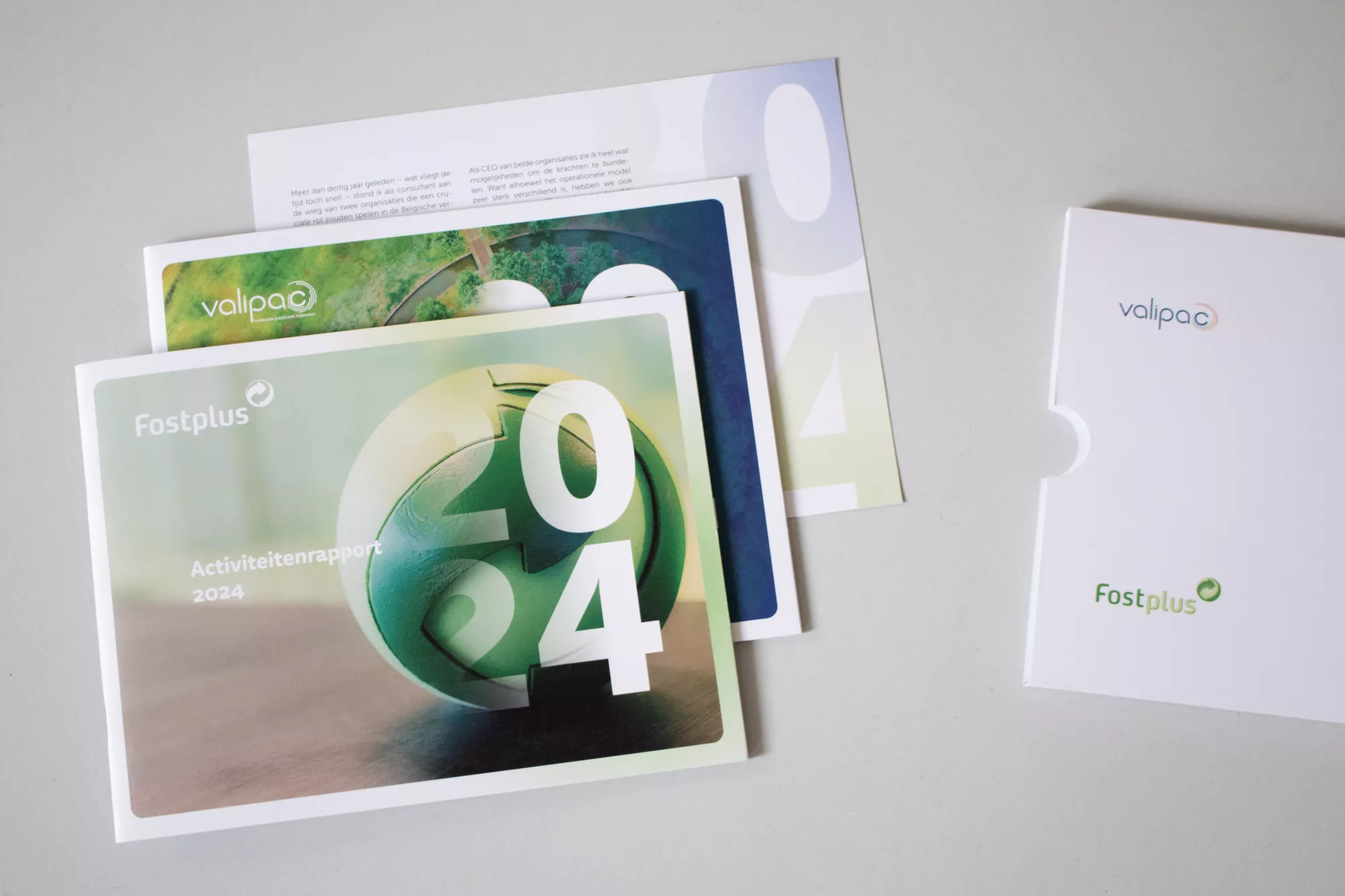 beeld van drie jaarverslagen gestapeld op elkaar, met ernaast de bijhorende enveloppe
