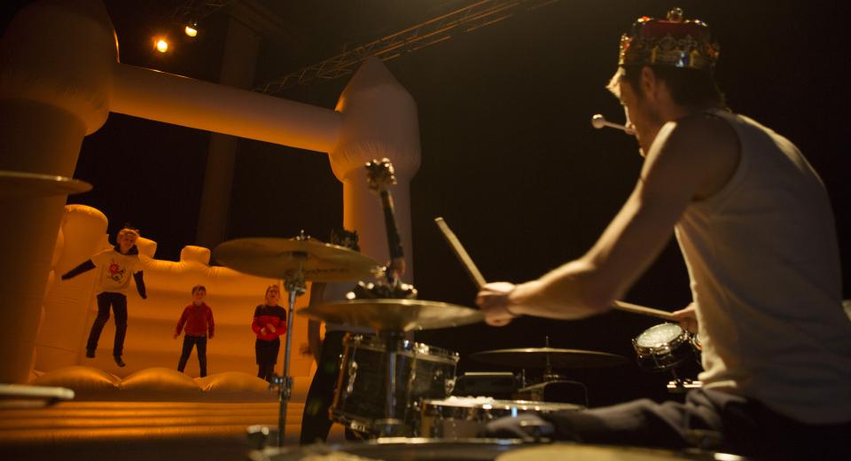 Kinderen op muzikaal springkasteel met drummer